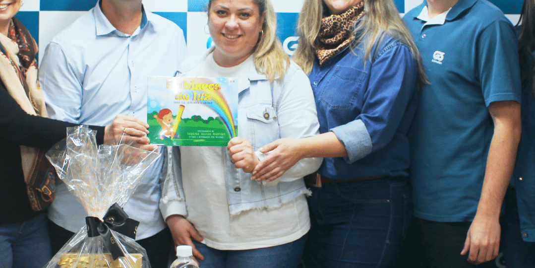 Equipe G3 Automation com cesta e livro infantil