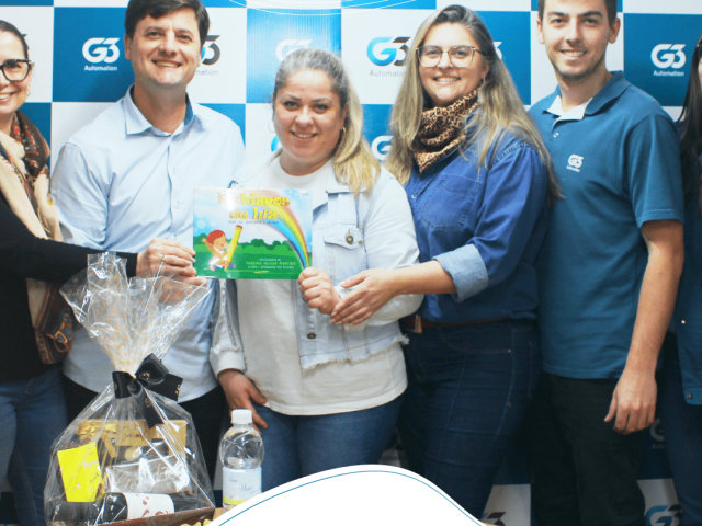 Equipe G3 Automation com cesta e livro infantil